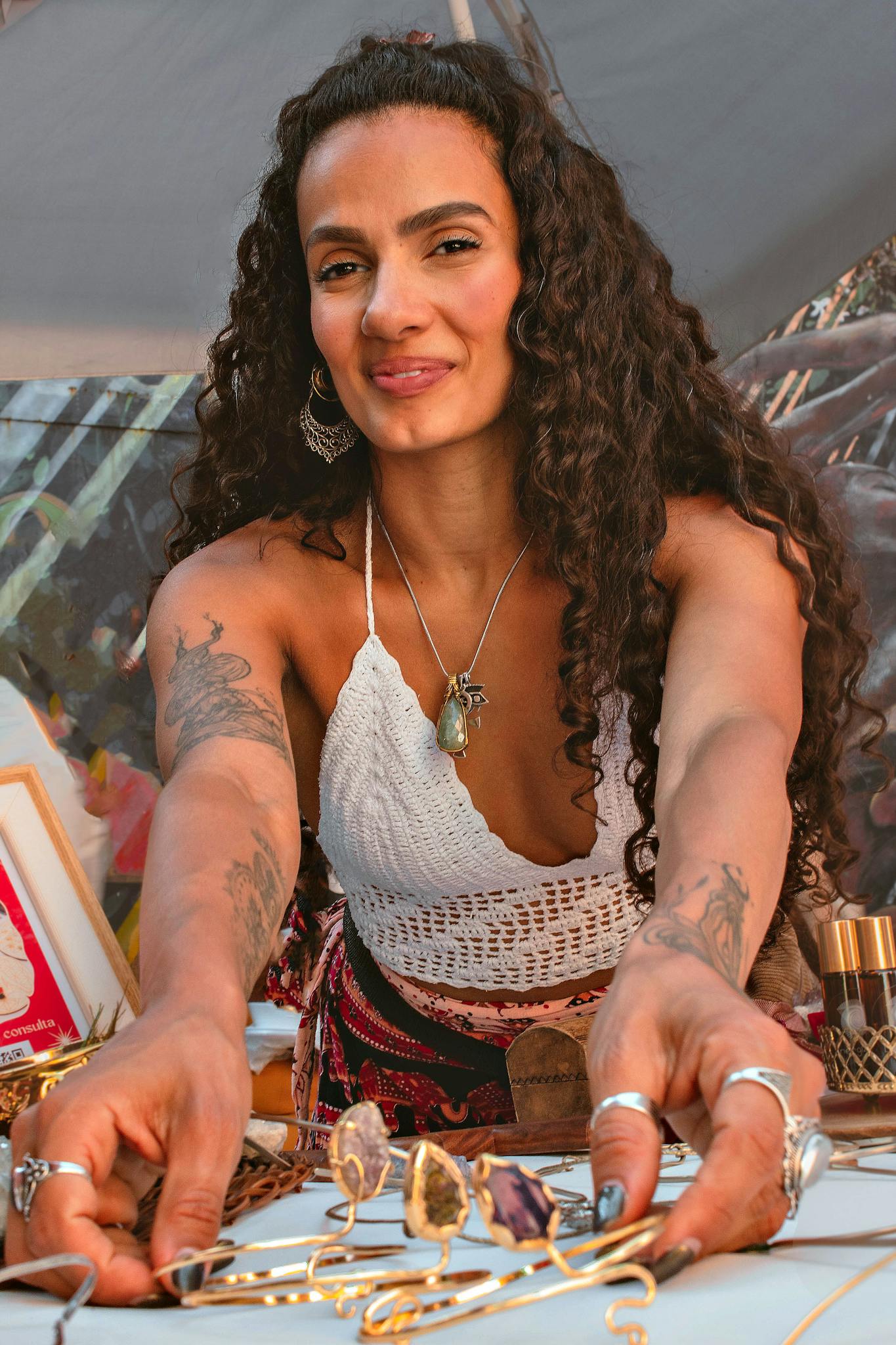Artisan woman displaying unique handmade jewelry at a craft fair table.