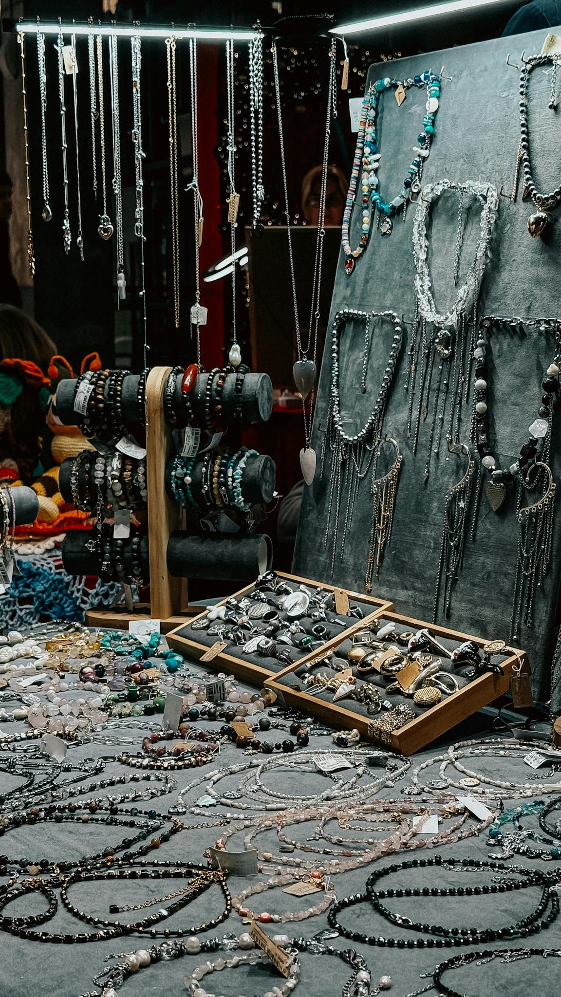 Artistic display of handmade jewelry in a vibrant market setting.