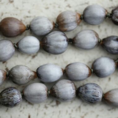Close-up of natural seed necklaces showcasing organic texture and earthy tones.